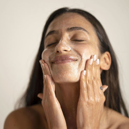 Woman using O Cosmedics cleanser on her face