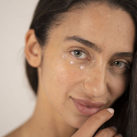 A beautiful woman applying O Cosmedics Eye Correct product 